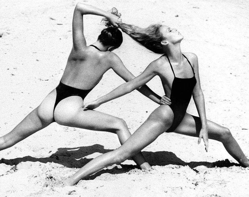 Топ-модели Лиза Тейлор и Джерри Холл, дерутся на пляже, в черных купальниках от Руди Гернрайха. Постановщик Полли Меллен. Сентябрь 1975 года.